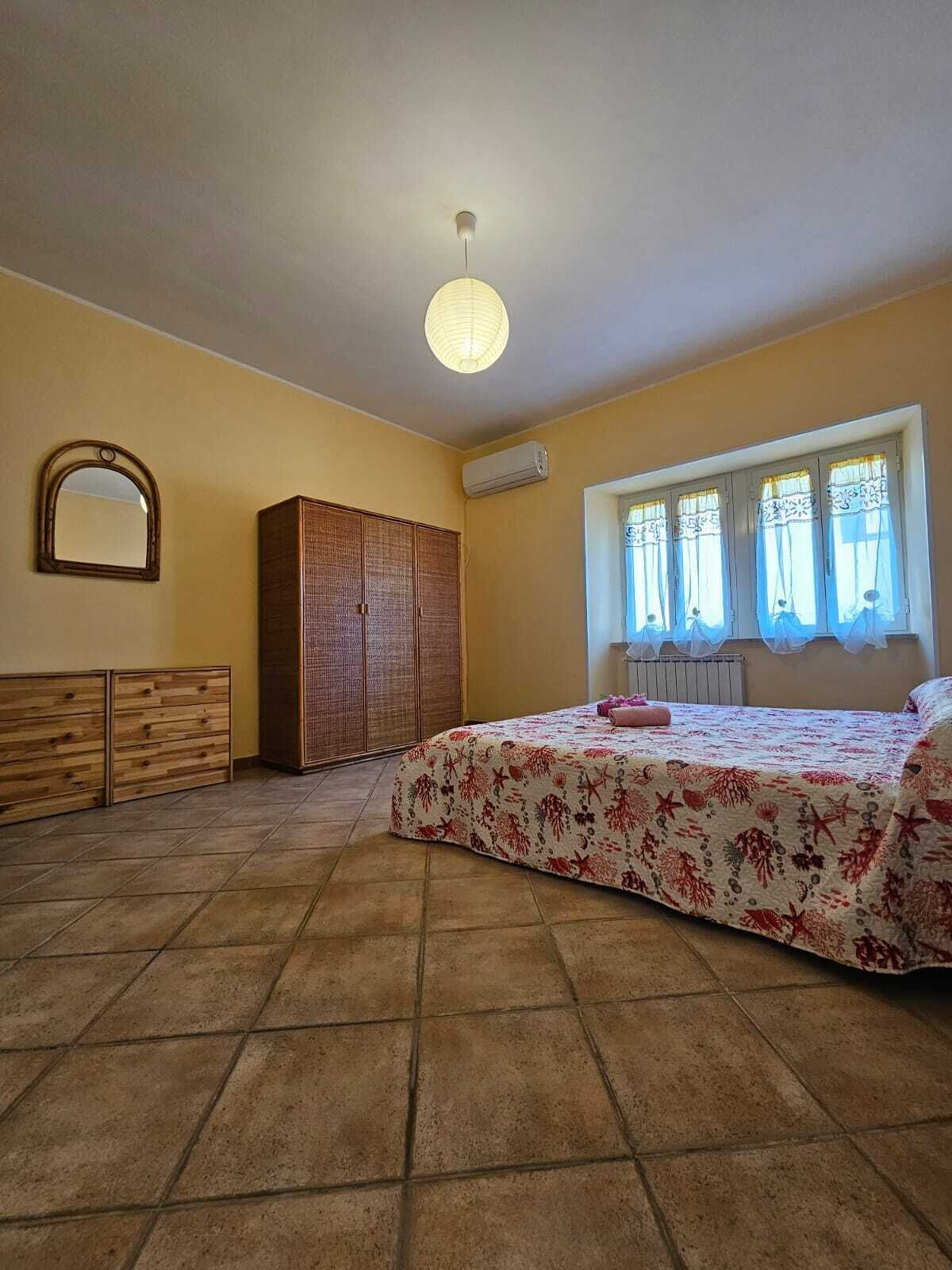 Une chambre à coucher avec un lit, une armoire et une fenêtre avec des rideaux.