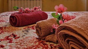Une chambre d’hôtel avec un lit, des serviettes pliées et un radiateur.