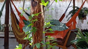 A hammock chair, a wooden post, and a monkey. - Pousada Nosso Canto Alter (Santarém)