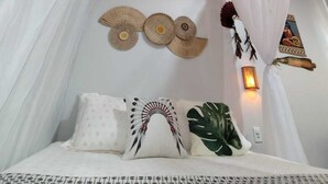 A bedroom with a canopy bed, decorative wall hangings, and a hanging light fixture. - Pousada Nosso Canto Alter (Santarém)