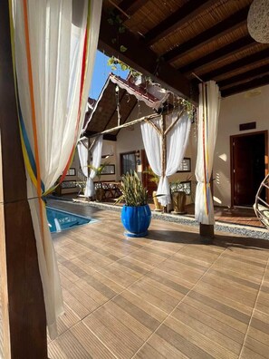 A covered outdoor area with a pool, potted plants, and a wooden ceiling. - Pousada Nosso Canto Alter (Santarém)