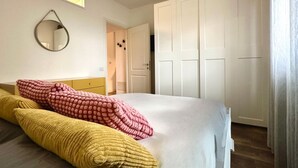 Ein Schlafzimmer mit Bett, Spiegel und Kleiderschrank.