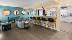 Un apartamento moderno con sala de estar, cocina y zona de bar.