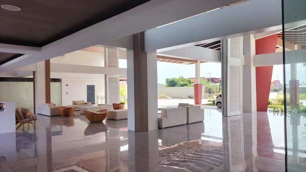 A spacious lobby with a modern design, featuring a mix of seating areas and a glass partition.