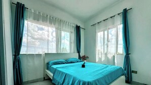Un dormitorio con cama, cortinas y ventana.
