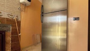 A stainless steel refrigerator in a kitchen with tiled flooring and a tiled backsplash. - Takdoum a Coté Merjan Market (Beni melalle)