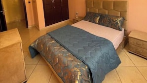 A bedroom with a bed, a wardrobe, a nightstand, and a dresser. - Takdoum a Coté Merjan Market (Beni melalle)
