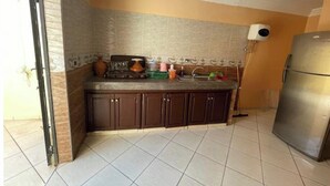 A kitchen with a tiled floor, a stove, cabinets, a sink, and a refrigerator. - Takdoum a Coté Merjan Market (Beni melalle)