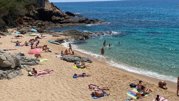 Une plage où l’on peut se détendre au soleil et se baigner, des falaises rocheuses et une eau d’un bleu limpide.