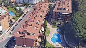 Un immeuble de grande hauteur doté de nombreux balcons, d’une piscine et d’une route au premier plan.