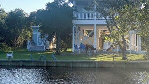 A two-story building with a balcony, a pond, and a sign with the number 2139.
