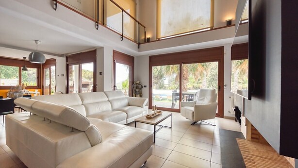 A spacious living room with a large sectional sofa, a coffee table, and a TV mounted on the wall. - Villa "Costacabana - Marcella" with Private Pool, Private Terrace & Wi-Fi (Lloret de Mar)