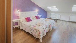 A bedroom with two beds, a white nightstand, a purple wall, and skylights. - Tradition Rural El Tío Ricardo Country House – Private Pool & Garden in Segovia (NIEVA)