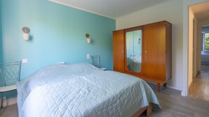 Ein Schlafzimmer mit einem Bett, einem Kleiderschrank und einem Spiegel.