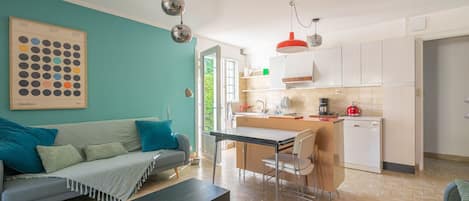 Un apartamento moderno con sofá, mesa de comedor y zona de cocina.