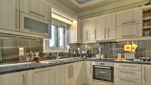 Una cocina moderna con alacenas de madera clara, una campana extractora de acero inoxidable y un horno empotrado.
