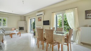Amplia sala de estar con una mesa de comedor, sillas, un sofá y una chimenea.