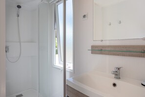 A bathroom with a shower, a sink, a mirror, and a window. - Mobile Home on Family Campsite with Pools (Saint-Jean-de-Monts)