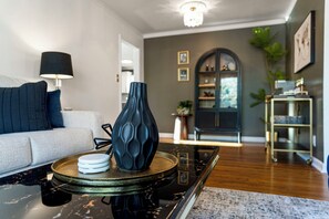 Una sala moderna con un sofá, una mesa de centro, una lámpara y un jarrón decorativo.