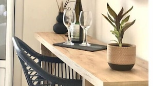 A wooden table with a mirror, a bottle, two glasses, and a potted plant. - Studio Apartment 'Sunset Premium  11' with Sea View, Wi-Fi and Air Conditioning (Lefkada)