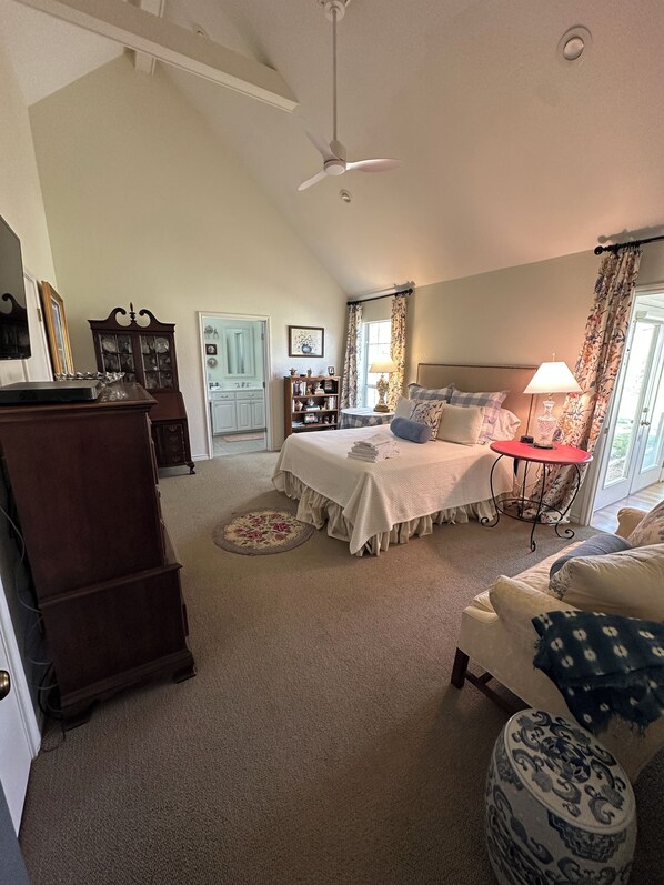 A bedroom with a bed, a desk, a chair, a lamp, and a ceiling fan. - 3 bed, 3 bath ranch house in Round Top, TX main square with large porch & views. (Round Top)