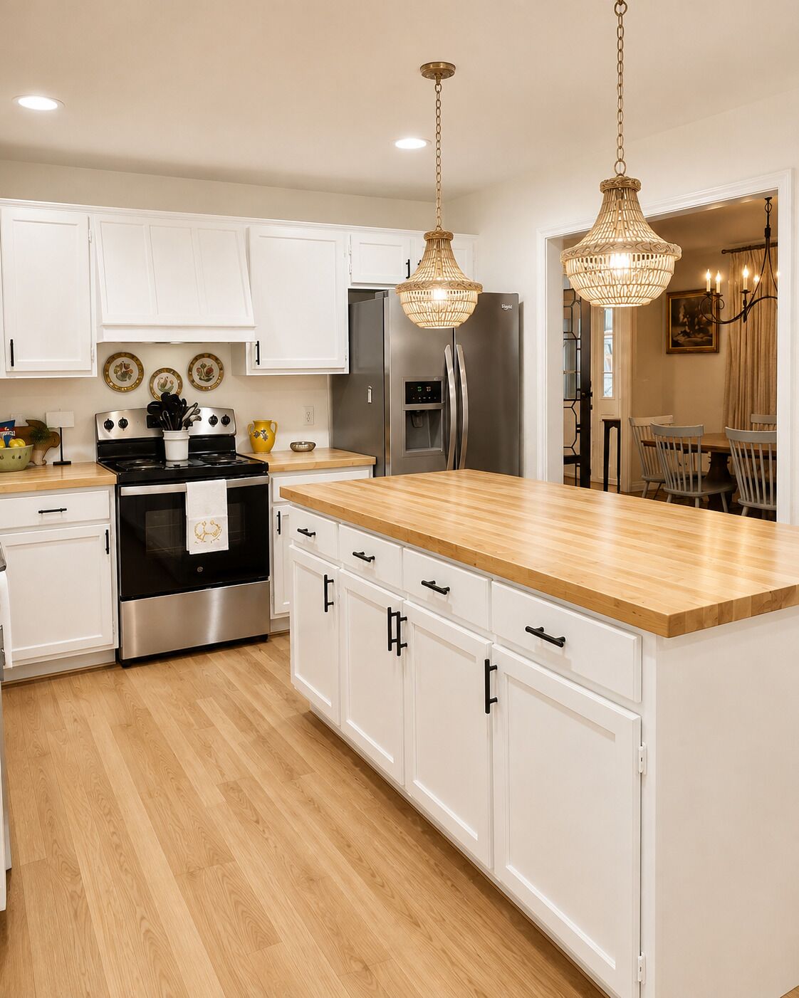 A modern kitchen with white cabinets, stainless steel appliances, and a wooden countertop.