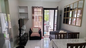 A living room with a sofa, a dining table with chairs, a fan, and a TV stand. - Antonioville Subdivision (Mandaue)