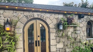 Un edificio de piedra con un doble puerta y un cartel encima que dice "THE WELL".