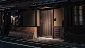 A traditional Japanese building with a wooden entrance, a sloped roof, and a small outdoor seating area. - Saju Kyoto (Kyoto)