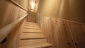 A wooden staircase with a handrail, leading to a landing with a light fixture. - Saju Kyoto (Kyoto)