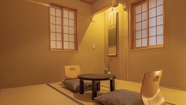 A traditional Japanese room with tatami flooring, a low table, and cushions. - Saju Kyoto (Kyoto)