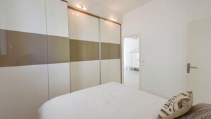 Une chambre à coucher avec un lit, une armoire et un miroir.