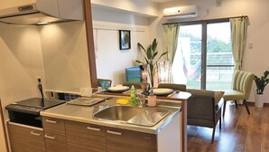 Una cocina moderna con una isla central, armarios de madera y un comedor con una silla y una mesa.
