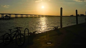 A sunset over a body of water with a pier extending into the water. - Florida Beach Hideaway 2A– Near the Beach • Pool • Fast WiFi • free Parking (Fort Myers)
