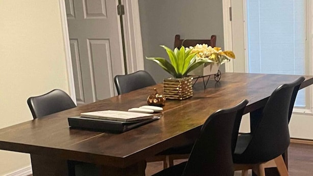 A dining table with four chairs, a vase with flowers, and a small decorative item on the table. - The Diamond Escape Murfreesboro Arkansas 3 miles to Crater of Diamond State Park (Murfreesboro)