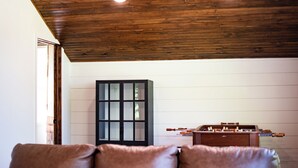 A room with a wooden ceiling, a black cabinet, and a foosball table. - Updated Getaway in the hills of southern Indiana. Minutes from Starve Hollow SRA (Vallonia)