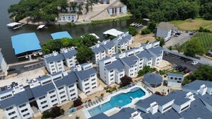 Un complejo residencial con varios edificios de apartamentos, una piscina y una zona de embarcadero.