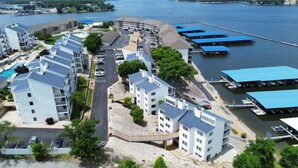 Un hotel frente al agua con varias edificaciones, un estacionamiento y barcos amarrados.