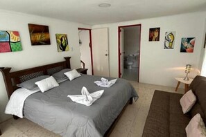 Relax in this inviting space with a comfortable bed, sofa, and abstract art.
