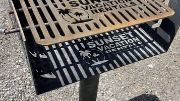 Ein Metallgrill mit der Aufschrift 'SUNSET VACATION RENTAL'.