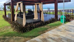 A covered outdoor seating area with a view of the ocean. - Cupe Beach Living by La Playa (Ipojuca)