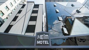 Un hôtel au design moderne, avec une enseigne bien visible indiquant « HEIM MOTEL ».