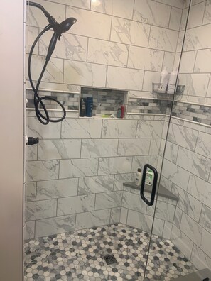 Een douche, handdoeken, zeep, shampoo
