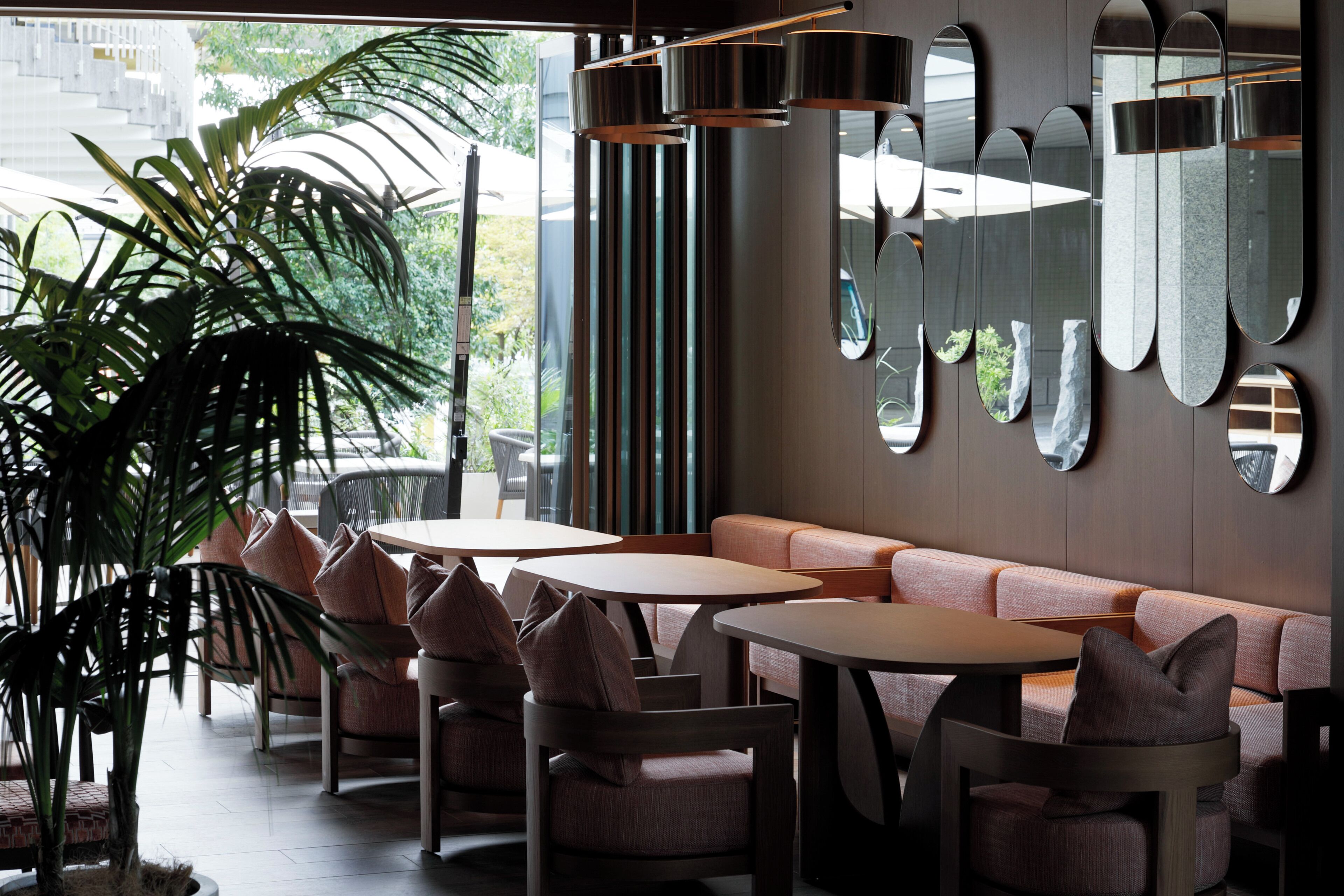 A modern interior with seating, tables, and a large mirror wall.