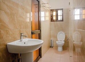 Baño con lavamanos, inodoro y ventana.