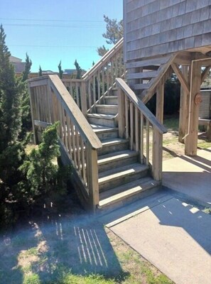 Stairs lead to a covered area with a tree and pathway.