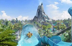 Ein Wasserpark mit einer großen, bergähnlichen Struktur im Hintergrund und mehreren Wasserrutschen im Vordergrund.