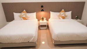 A hotel room with two beds, a nightstand with a lamp, and a small plant. - Hotel H4  (El Paraíso)