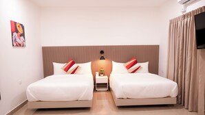 A hotel room with two beds, a headboard, a nightstand with a lamp, a painting on the wall, and a TV on the right. - Hotel H4  (El Paraíso)