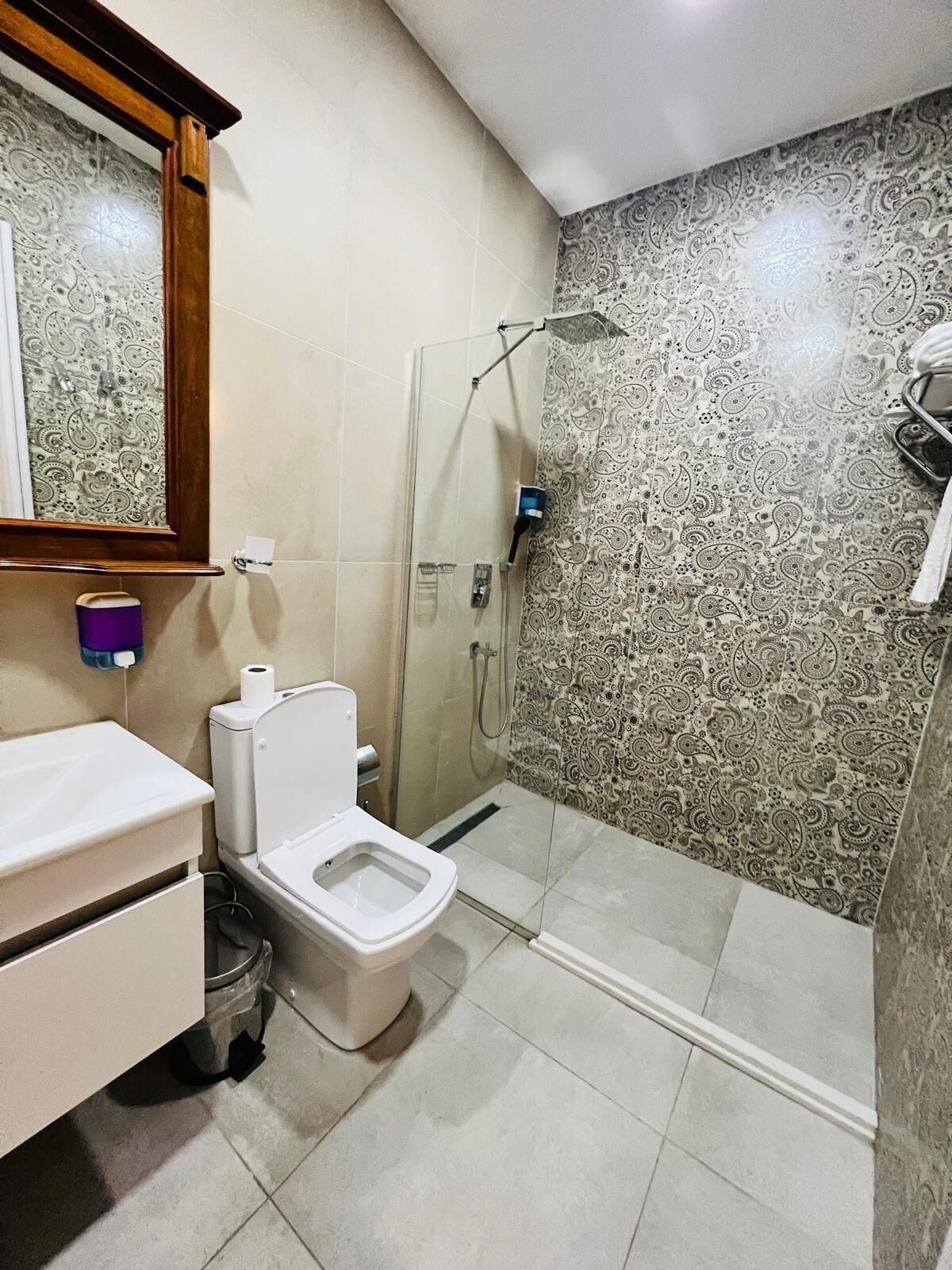 A bathroom with a toilet, bidet, and shower.